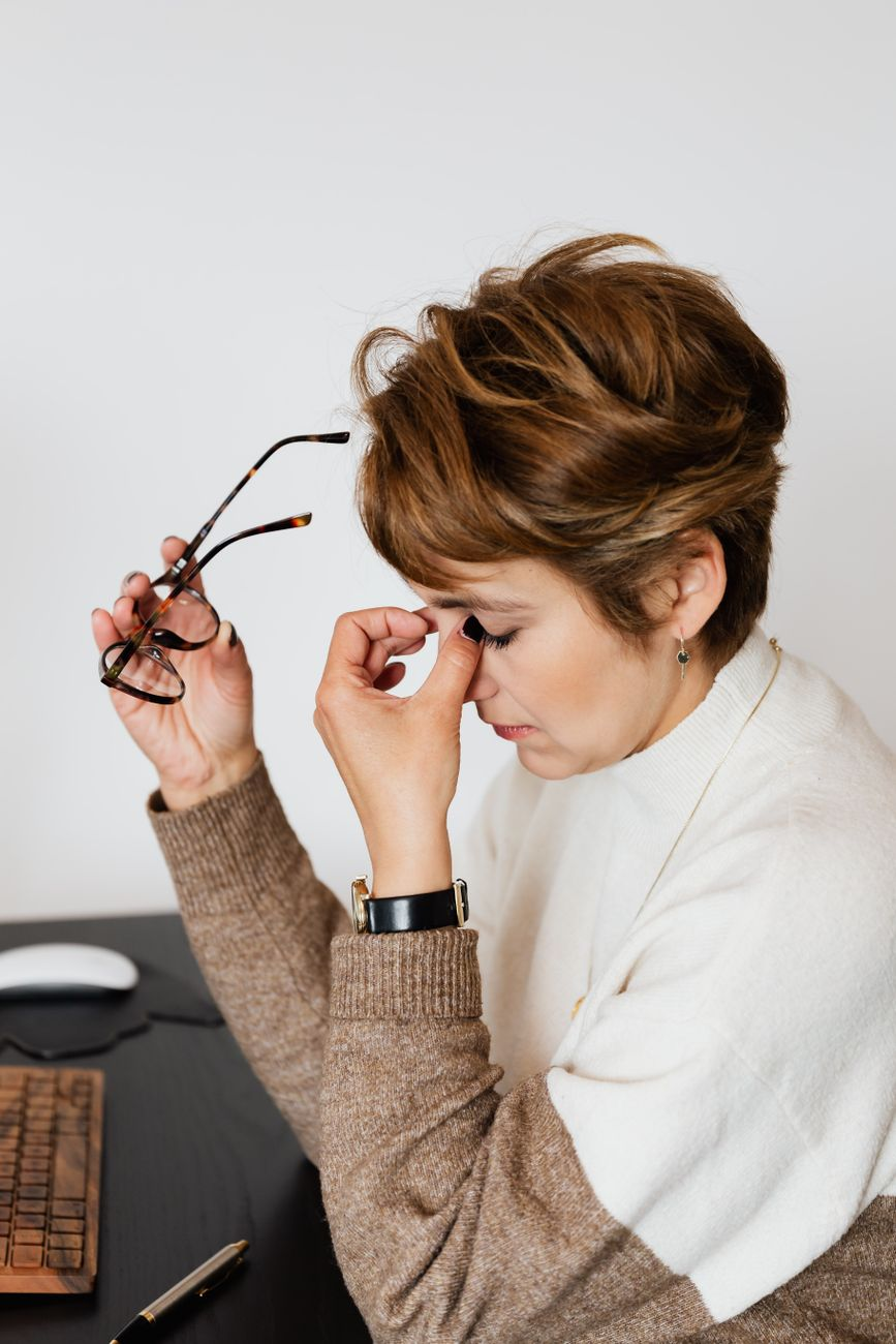Exhausted professional sitting at a desk with head in hands, showing signs of burnout