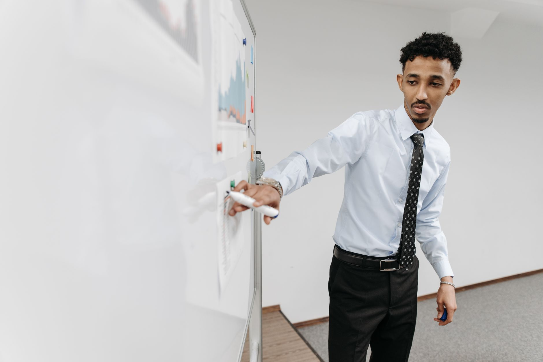 Manager and employee reviewing goals together at a whiteboard in an open office